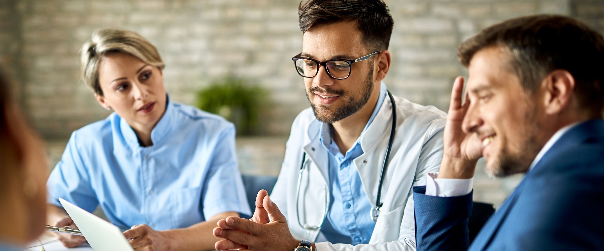 Ein Team von Ärzten und Geschäftsleuten bei einer Besprechung im Büro am Computer.